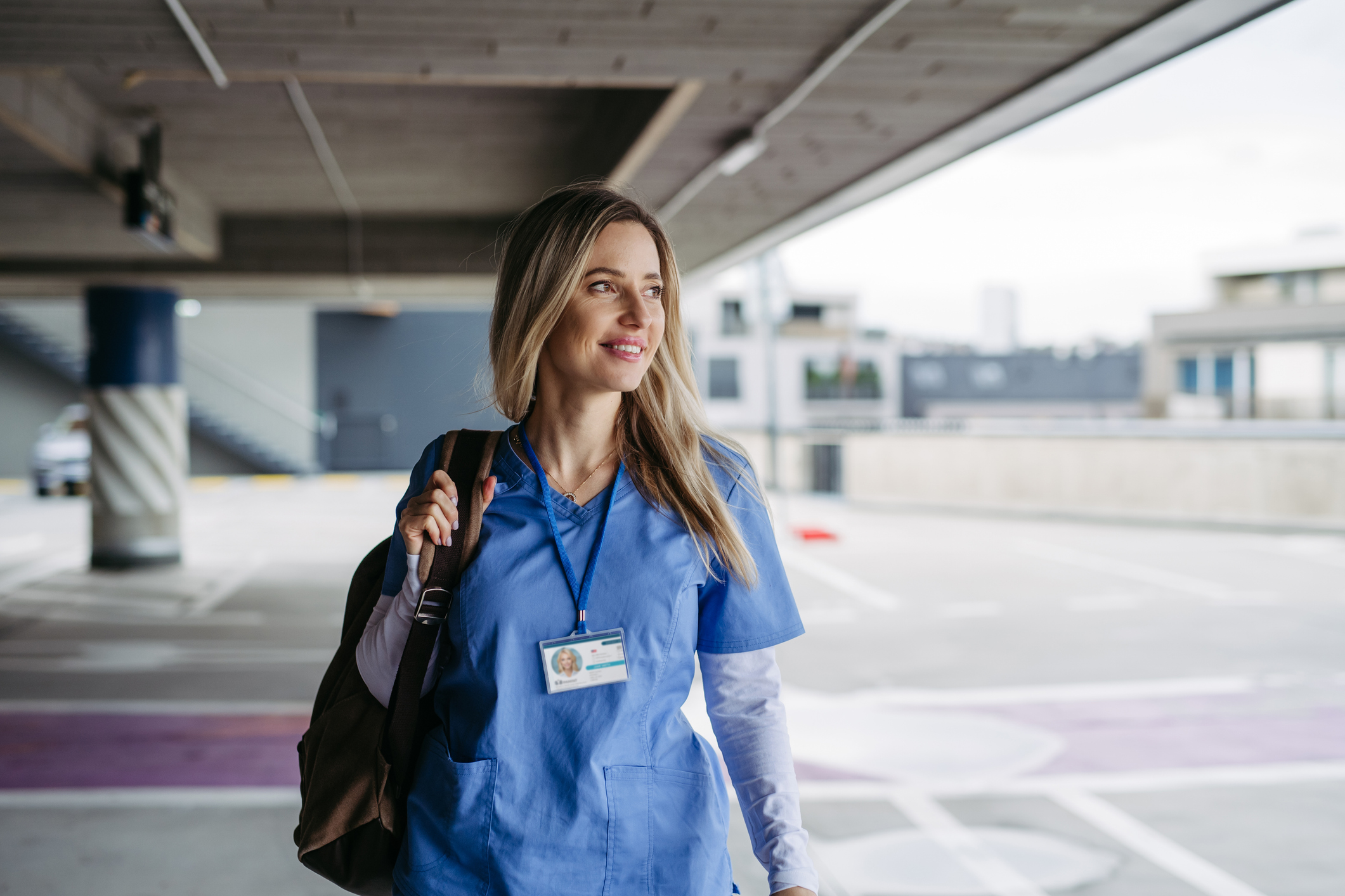 Nurse, doctor walking across hospital parking lot, going home from work. Work-life balance of healthcare worker.