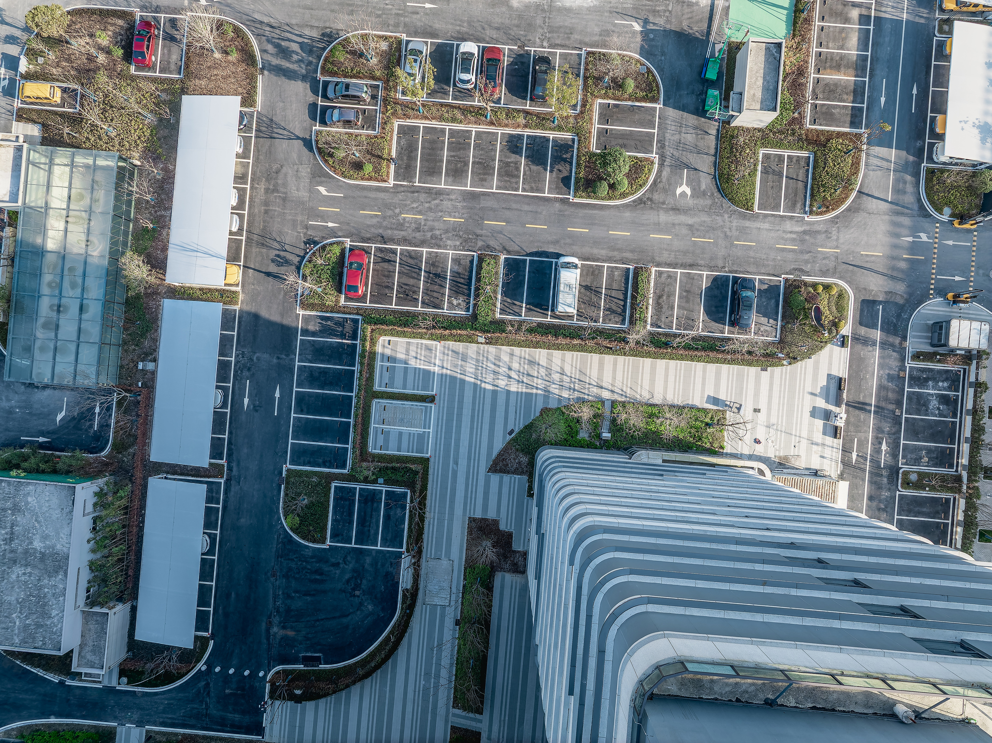 Aerial top view of empty asphalt road and parking lot with modern commercial office building exterior.