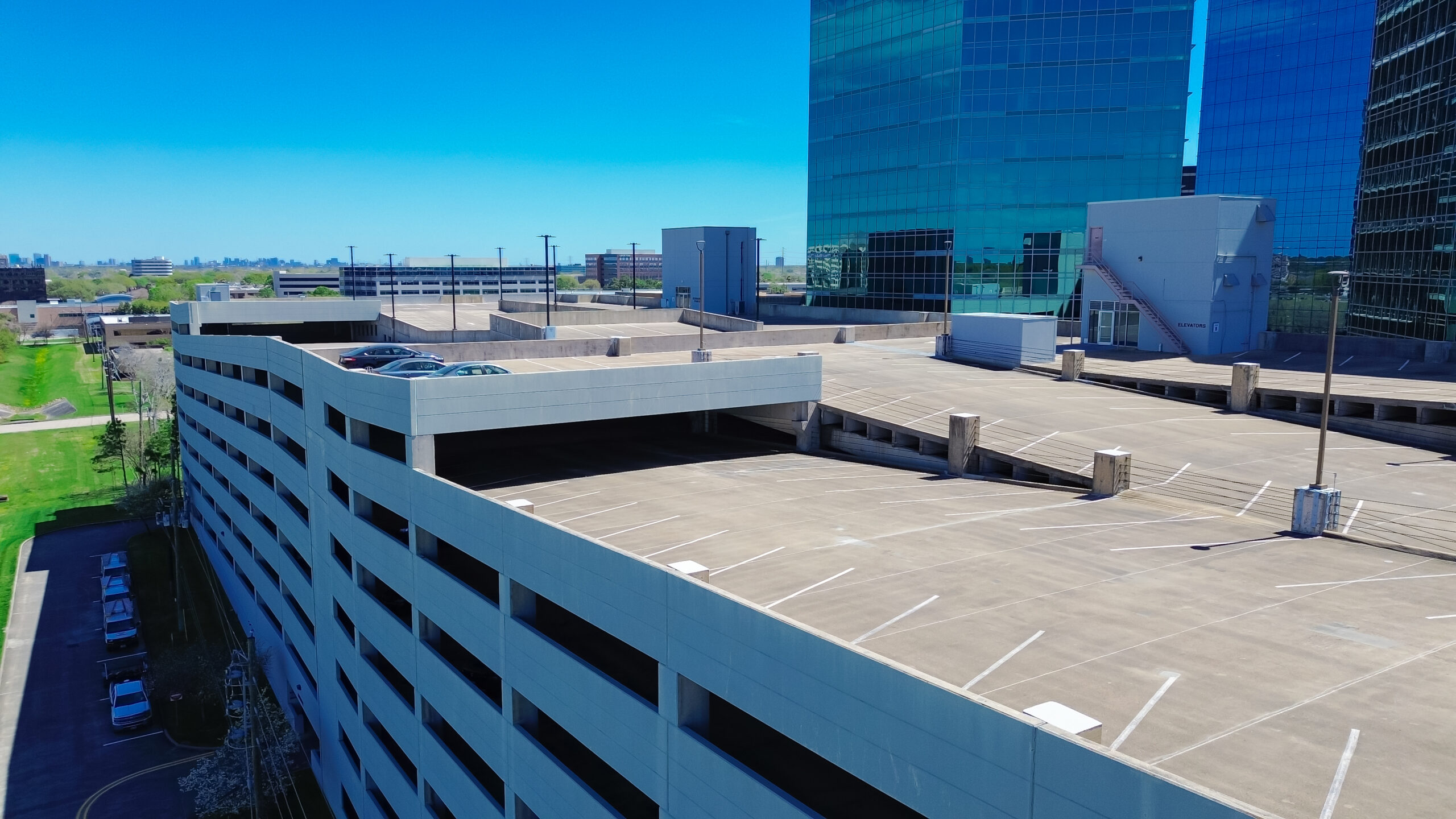 Close-up rooftop parking optimum use of available space at multistorey car park in busy Westchase business district, western Houston, Texas, rooftops structures space-efficient solution, aerial